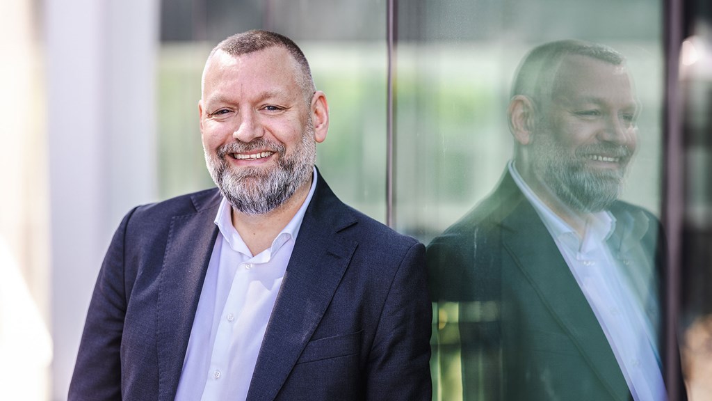 Andreas Bremo reflected in the window he is leaning against.