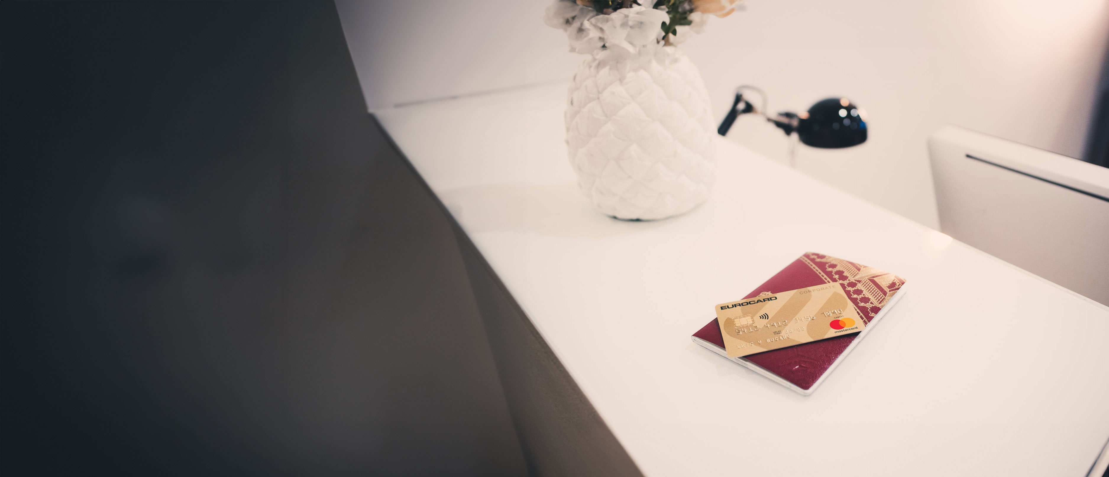 Eurocard Gold on passport on white counter.